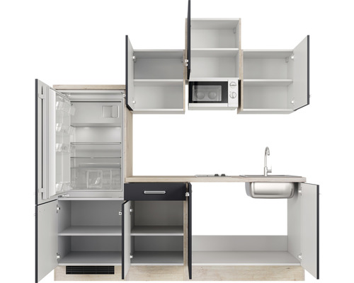 Keukenblok met koelkast, magnetron, gootsteen en open kasten.