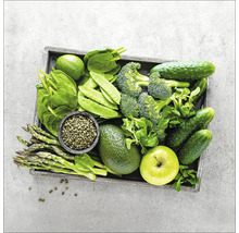 Een houten kist gevuld met groene groenten zoals komkommers, broccoli, erwten, asperges en sla