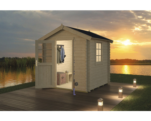 Houten tuinhuis met open deur aan het meer bij zonsondergang