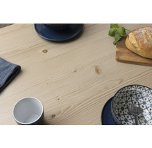 Detailweergave van een houten tafelblad met servies en brood