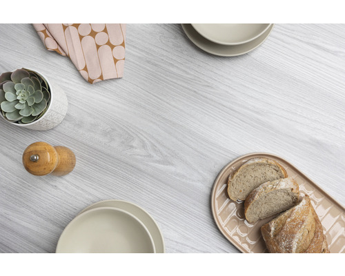 Decoratieve schikking met broodplank, servies, kruidenstrooier, vetplant en stoffen servet op houten tafel