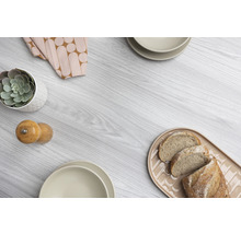 Decoratieve schikking met plant, servies en brood op een houten tafel