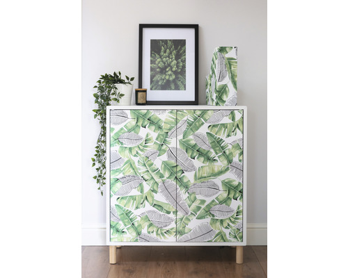 Decoratieve kast met bladerpatroon en houten poten in de woonkamer.