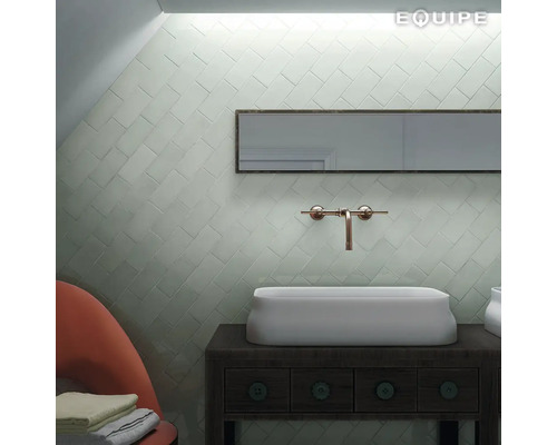 Badkamer met rechthoekige spiegel, wastafel, kraan en wandtegels in visgraatmotief