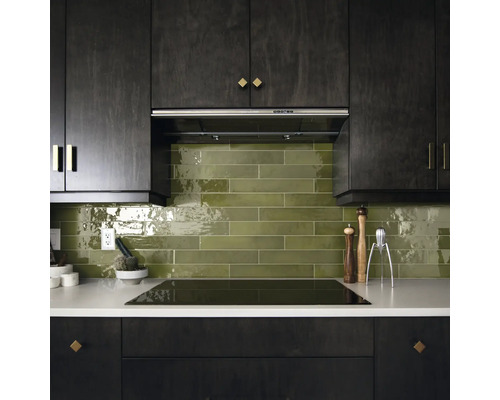 Keukenoverzicht met donkere kasten, groene tegels en kookplaat