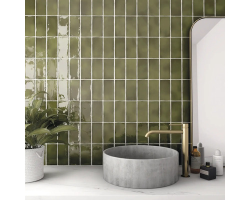 Badkamer met wandtegels, wastafel en kraan