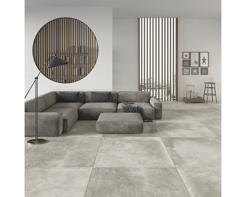 Woonkamer met modulaire bank, staande lamp en tegelvloer met steenlook