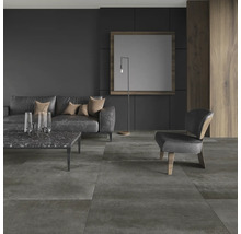 Moderne woonkamer met donkere vloertegels, bank en fauteuil.