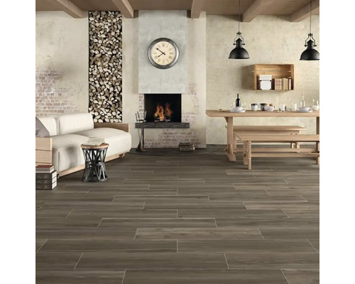 Woonkamer met houten vloer, open haard en rustieke meubels.