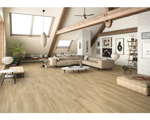 Lichte woonkamer met schuine daken, houten balken en vloertegels in houtlook.