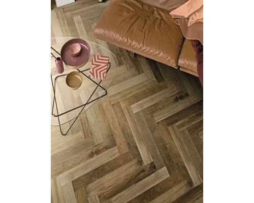 Woonkamer met visgraatparket, leren bank en glazen tafel