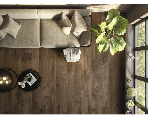 Bovenaanzicht van een woonkamer met houten vloer, bank, tafel en kamerplant