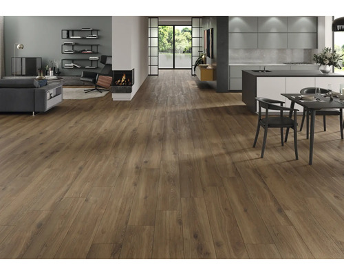 Lichte woonkamer met laminaatvloer in houtlook, open haard en open keuken.