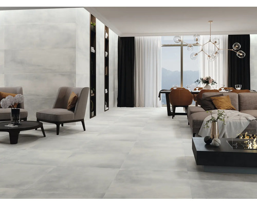 Lichte woonkamer met tegelvloer, fauteuils, bank en eettafel