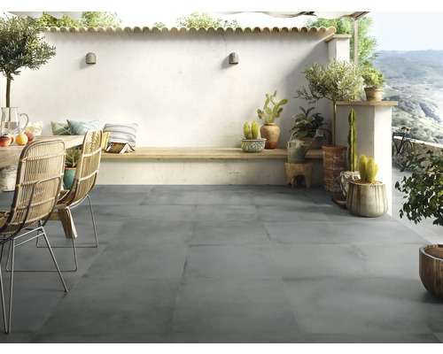 Terras met grijze vloertegels, tuinmeubelen en decoratieve planten