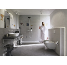 Lichte badkamer met douche, wastafel, toilet en bidet.