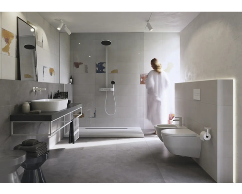 Lichte badkamer met douche, wastafel, toilet en bidet.