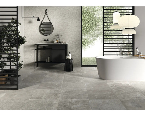 Moderne badkamer met ligbad, wastafel en grijze tegels