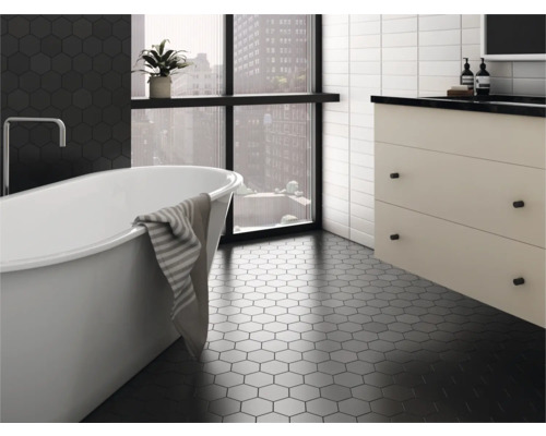 Badkamer met vrijstaand bad, wastafelonderkast en zeshoekige vloertegels.