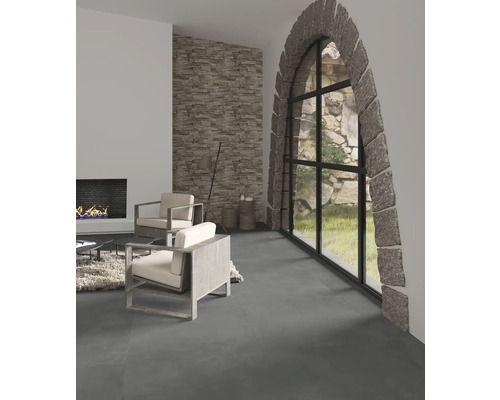 Woonkamer met stenen tegelvloer, stenen gevelmuur, open haard en ramen