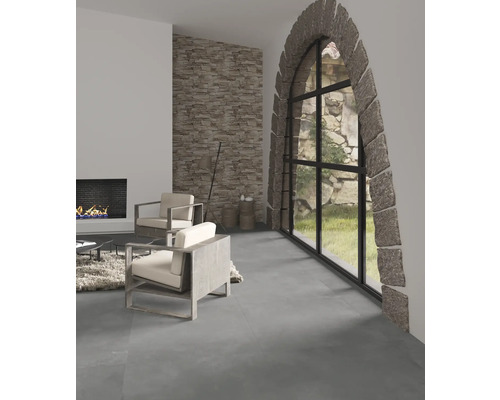 Woonkamer met open haard, natuurstenen muur en fauteuils