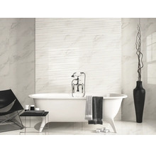 Badkamer met ligbad, tegelwand en decoratie