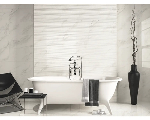 Badkamer met ligbad, tegelwand en decoratie