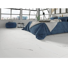 Lichte kamer met bed en vloertegels in marmerlook