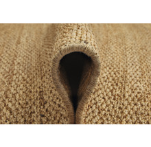 Gedetailleerde close-up van een opgerolde vloerkleed gemaakt van natuurlijke vezels.