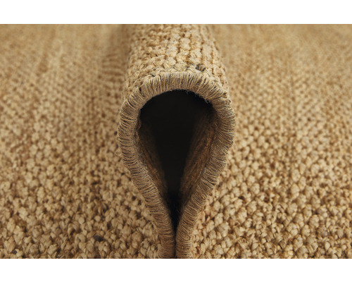 Gedetailleerde close-up van een opgerolde vloerkleed gemaakt van natuurlijke vezels.