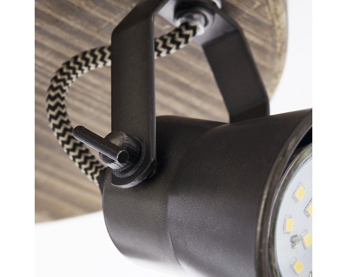 Detailopname van een plafondlamp met verstelbare spot en textielkabel