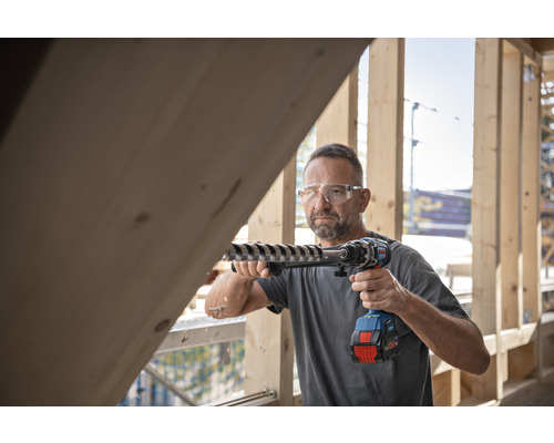 Man boort met accuboormachine in houten constructie