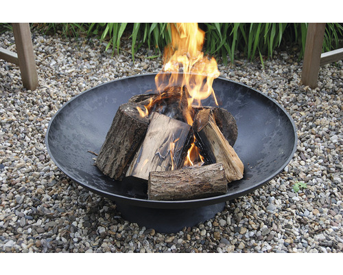 Vuurschaal met hout en vuur in de tuin