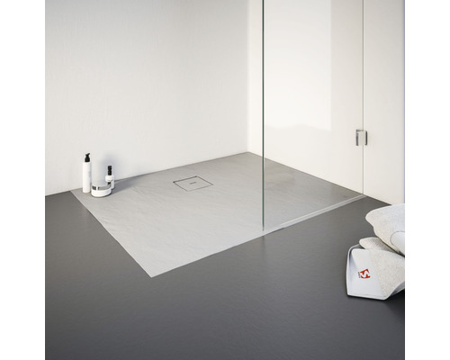 Gelijkvloerse douche met douchegoot en handdoeken in badkamer