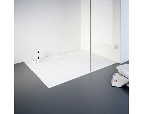 Gelijkvloerse douche met douchebak, glazen douchewand en handdoeken in de badkamer.