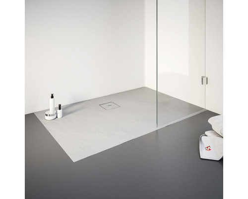 Badkamer met vlakke douche, glazen douchewand en verzorgingsproducten