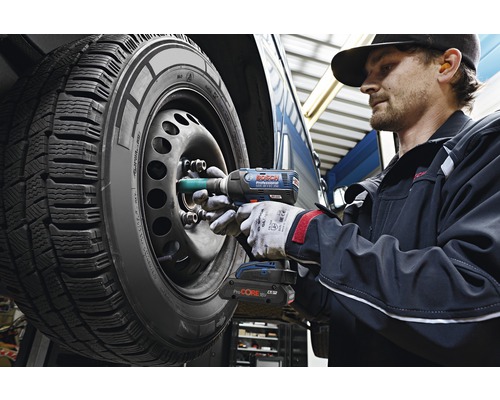 Een monteur gebruikt een accuslagschroevendraaier om de wielmoeren aan een autoband vast te draaien