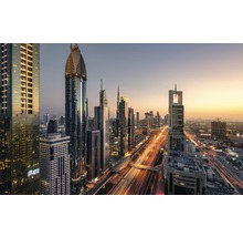 Skyline van Dubai met wolkenkrabbers en wegen bij zonsondergang.