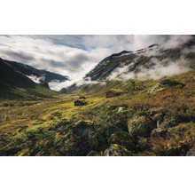 Landschap met bergen, wolken en hutten met grasdaken