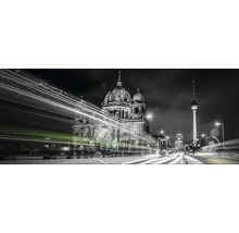 Zwart-wit foto van de Berliner Dom en de televisietoren ''s nachts met lichtsporen