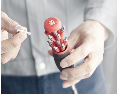 Multifunctionele schroevendraaier met verschillende bits wordt door een persoon vastgehouden