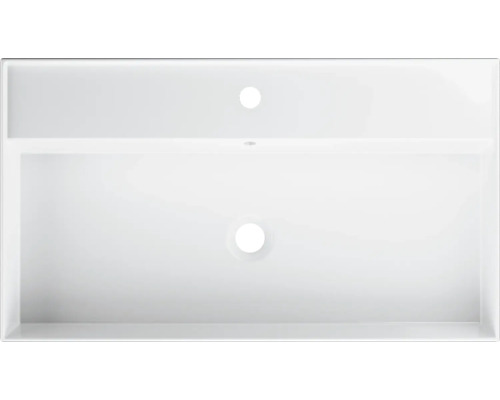 Bovenaanzicht van een witte wastafel met kraangat en overloop