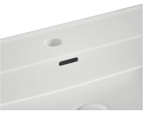 Detailopname van een wastafel met overloop en kraangat