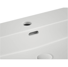 Detailopname van een witte wastafel met afvoer en kraangat