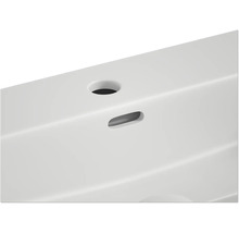 Detailopname van een wastafel met kraangat en overloop