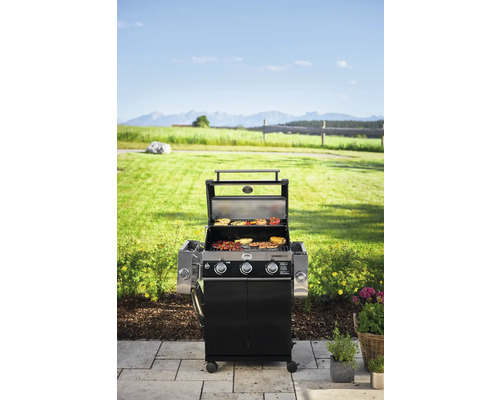 Gasbarbecue met eten op het rooster in de tuin