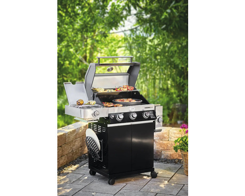 Gasbarbecue met voedsel op het grillrooster in de tuin