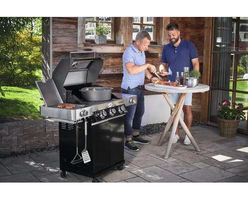 Gasbarbecue met twee mannen die buiten aan het grillen zijn