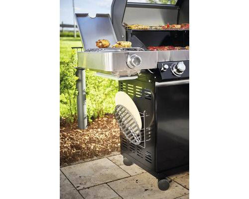 Gasbarbecue met voedsel op het rooster en zijbrander