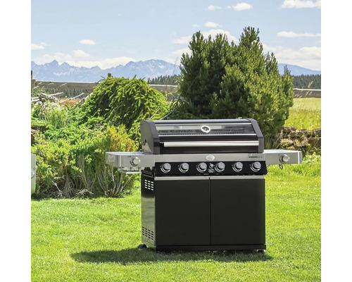 Zwarte gasbarbecue met onderkast en zijplanken in de tuin
